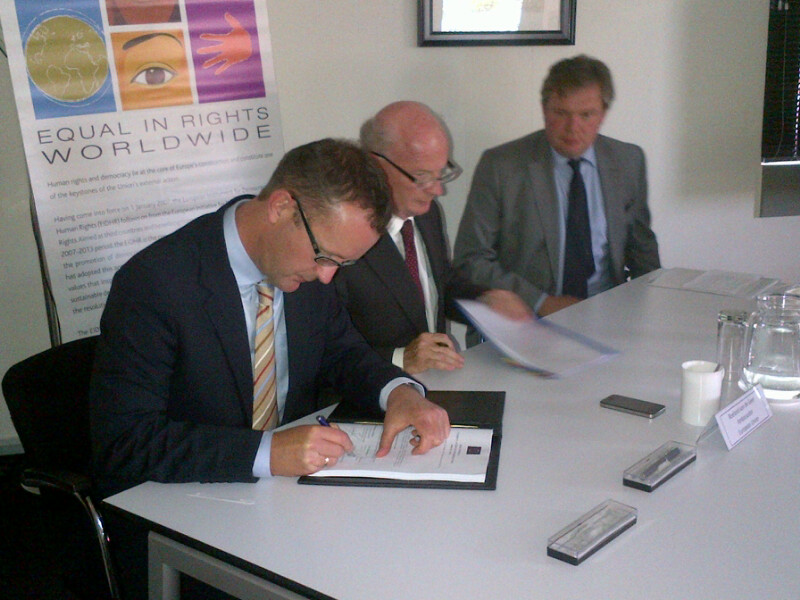 Prof. De Visser signing the grant agreement on behalf of the Community Law Centre. Seated next to him is EU Ambassador Van de Geer